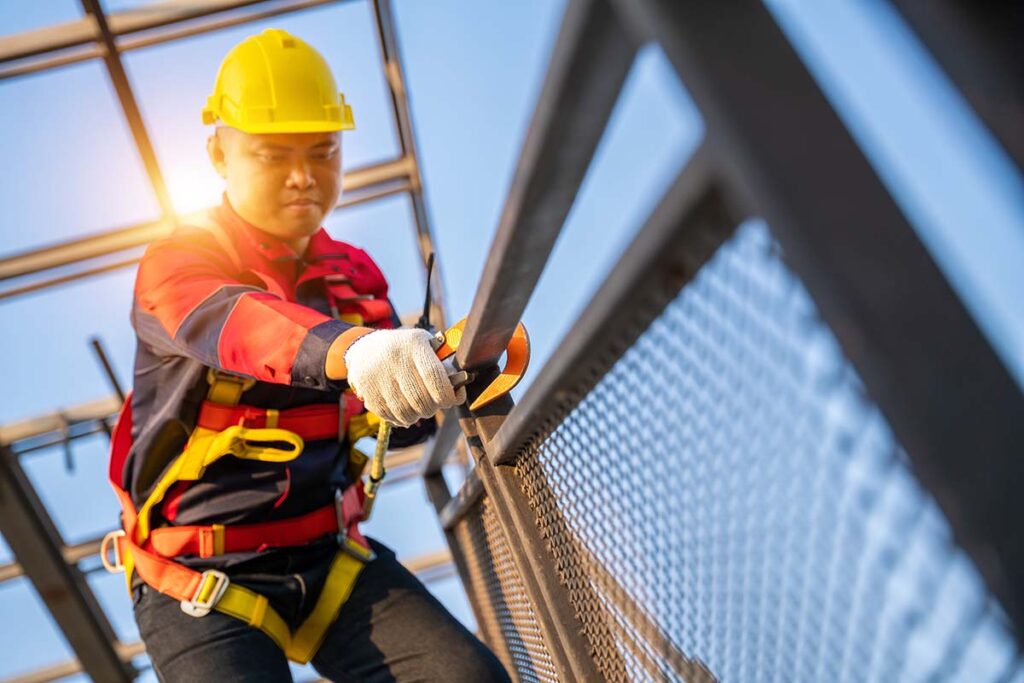 Worker using equipment to ensure his safety on scaffolding